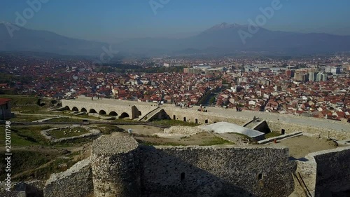 Panoramic drone shot flying over Prizren fortress towards sprawling city photo