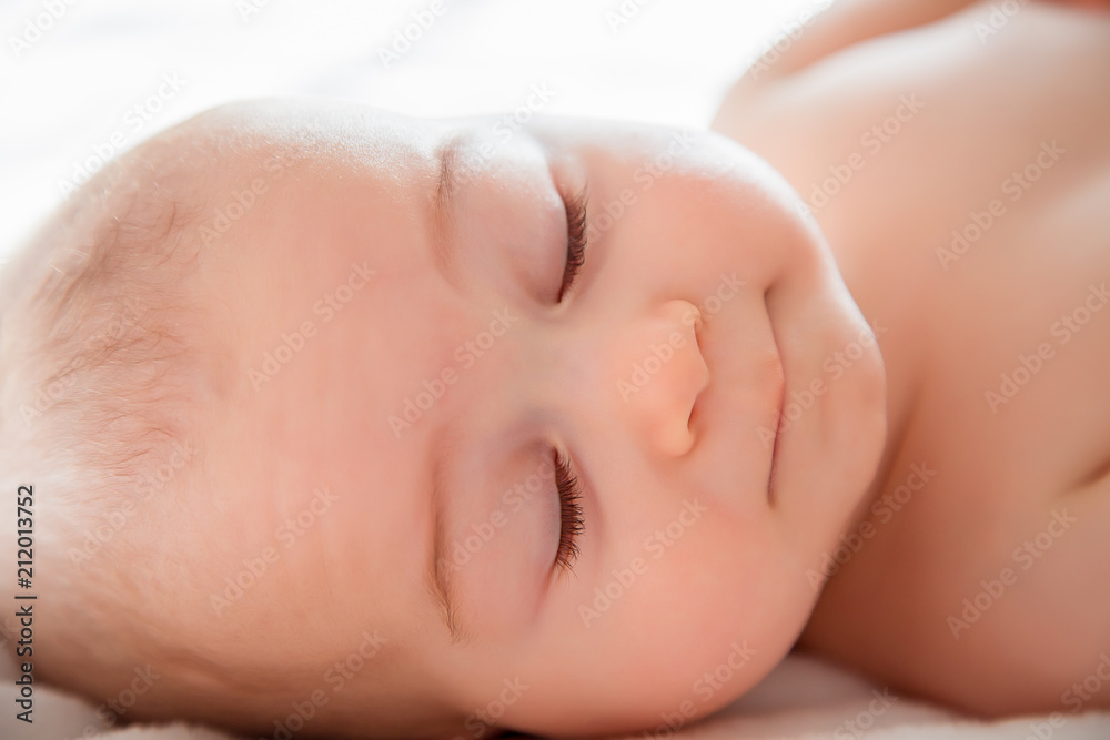A toddler boy sleeping comfortably on white bed A toddler boy sleeping comfortably on white bed