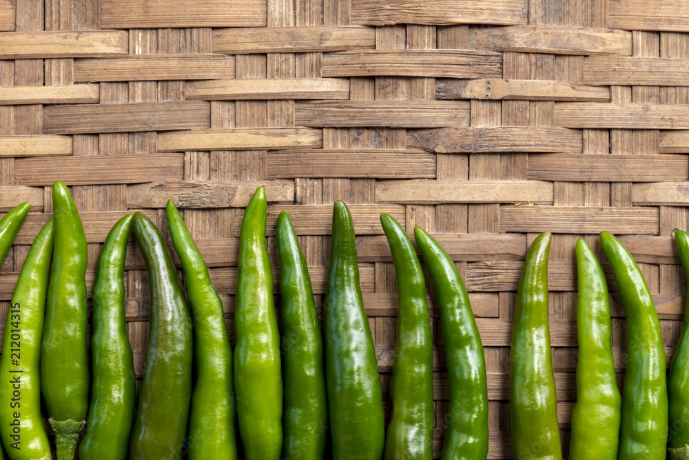 Fresh green chilli paste on bamboo background. Space left to place text. Thai spices. Close up top view. Fresh green chilli paste on bamboo background. Space left to place text. Thai spices. Close up top view.