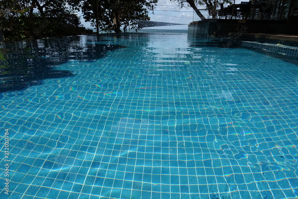 blue swimming pool, outdoor swimming pool with big tropical trees