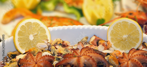 plate of fresh fish served with two slices of lemon served