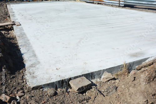 Slab-on-grade foundation on house construction site. Monolithic slabs are foundation systems constructed as one single concrete pour that consists of a concrete slab.