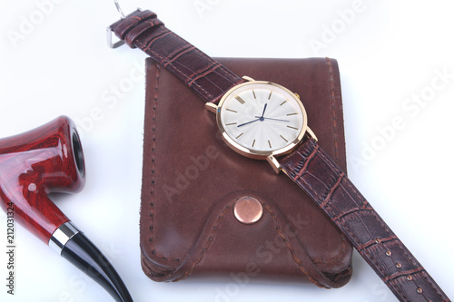 Men's accessories for business and rekreation. Leather wallet, watch and smoking pipe on white background.. Top view composition.