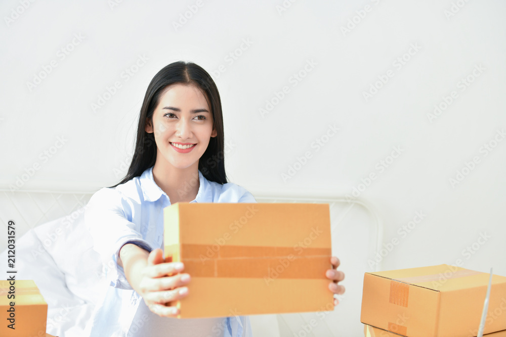 Sme business concept. Young people are packing their packages.Delivery business Small and Medium Enterprise (SMEs). Young woman is working in the house.Young Owner Start up for Business Online. Sme business concept. Young people are packing their packages.Delivery business Small and Medium Enterprise (SMEs). Young woman is working in the house.Young Owner Start up for Business Online.
