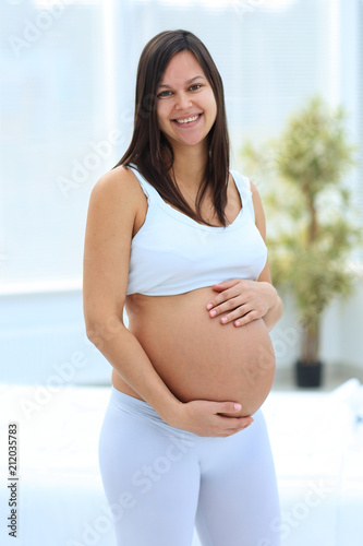 portrait of young pregnant woman on a light background. Free Download portrait of young pregnant woman on a light background. - GFXLoad