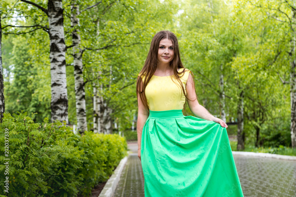 Beautiful young woman near green trees in the park Beautiful young woman near green trees in the park