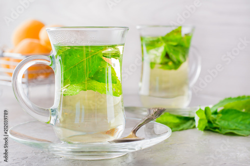 Hot tea with mint leaves in transparent glasses on the table