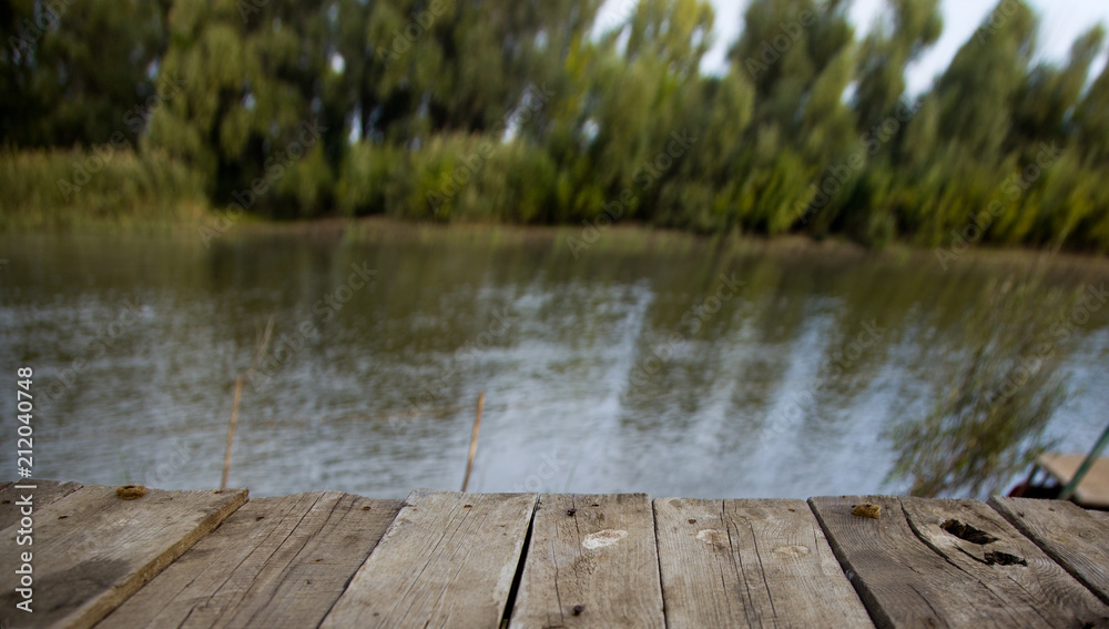 Wooden bridge, pier near the river, bridge, pier, wooden.A natural blurred landscape of the river in summer at sunset. Astrakhan Region, Russia Wooden bridge, pier near the river, bridge, pier, wooden.A natural blurred landscape of the river in summer at sunset. Astrakhan Region, Russia