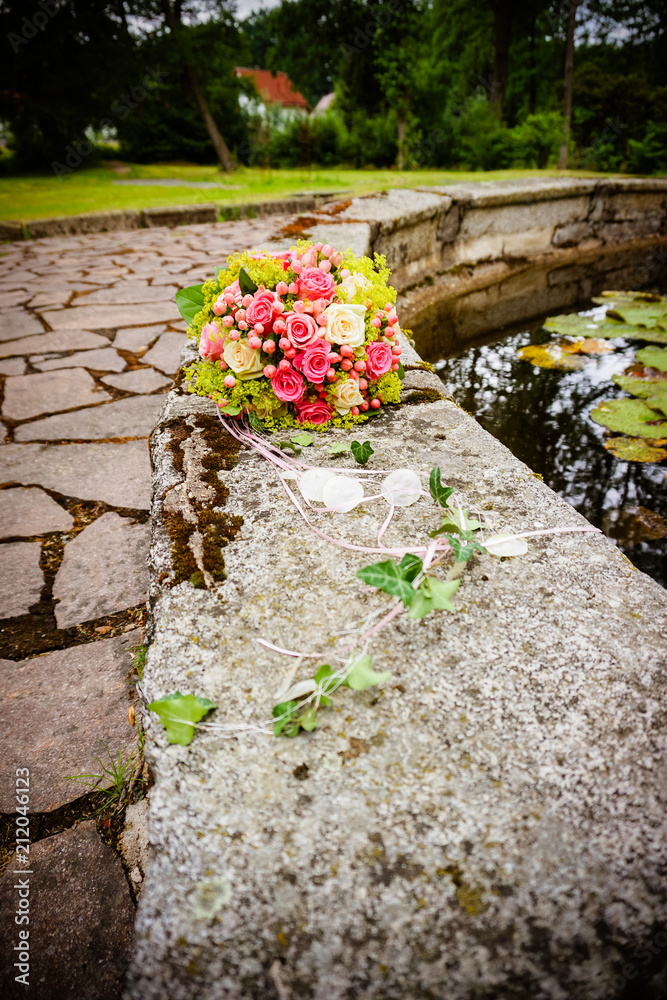Romantic wedding fresh colorful bouquet in a daylight on the background of old baroque historical castle with park and fountain Romantic wedding fresh colorful bouquet in a daylight on the background of old baroque historical castle with park and fountain