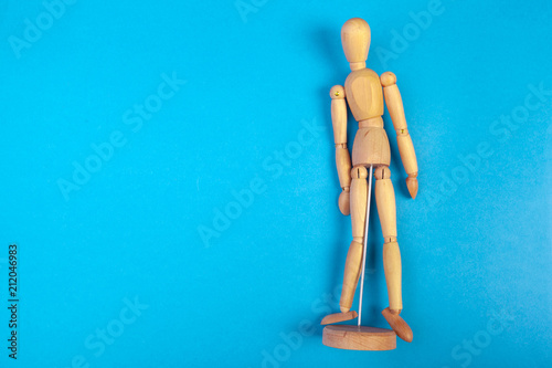 Toy wooden doll on colored blue background photo