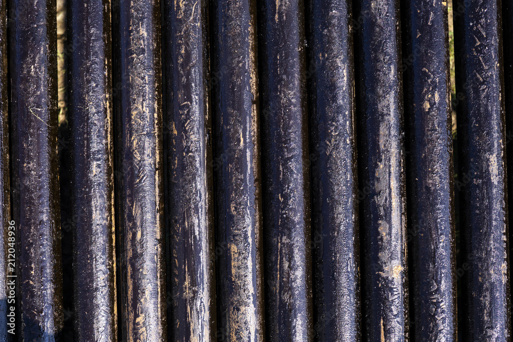 Fototapeta premium Oil Drill pipe. Rusty drill pipes were drilled in the well section. Downhole drilling rig. Laying the pipe on the deck. View of the shell of drill pipes laid in courtyard of the oil and gas warehouse.