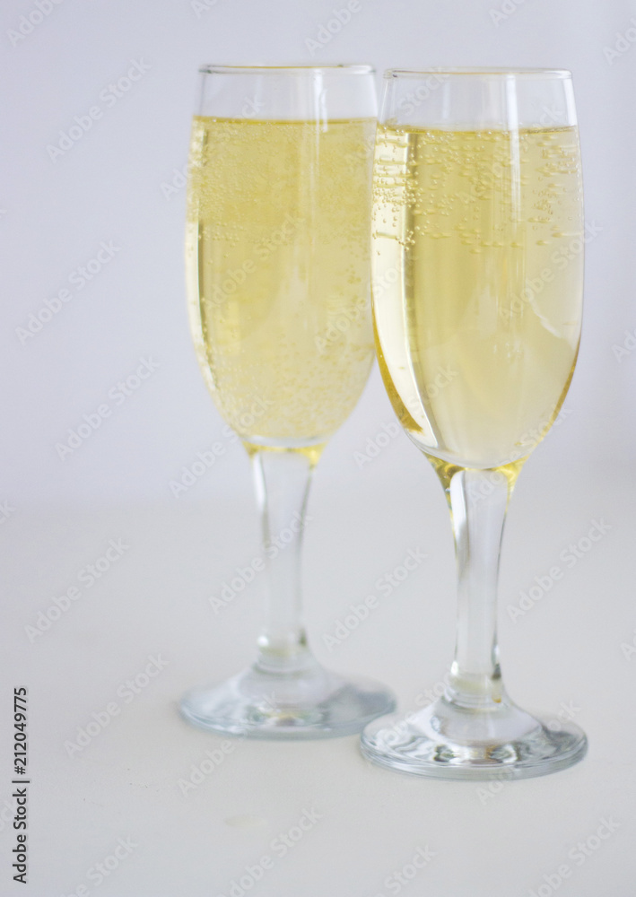 two glasses with champagne on a white background. two glasses with champagne on a white background.