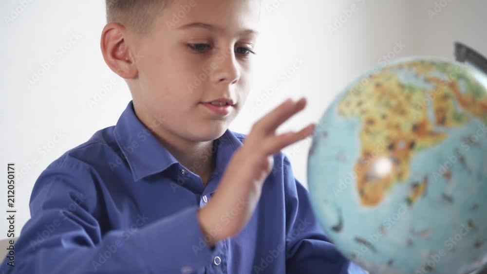 Schoolboy studying the geography of the earth with a globe.
Schoolboy studying the geography of the earth with a globe.