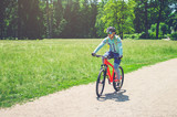 Cyclist in helmet on orange bike riding in park