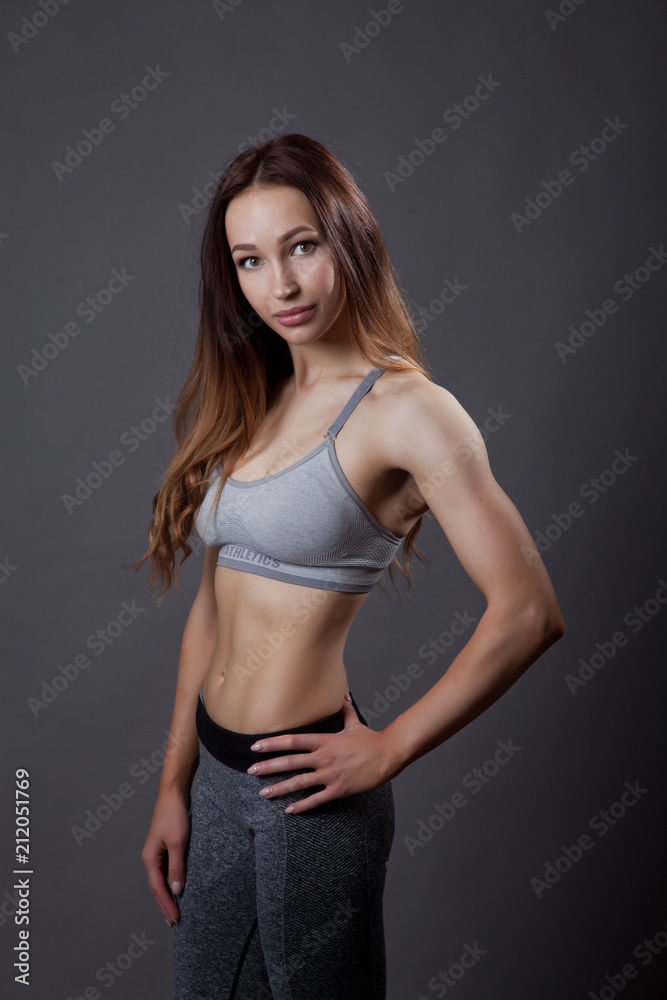 fitness trainer relaxed posing on grey background fitness trainer relaxed posing on grey background