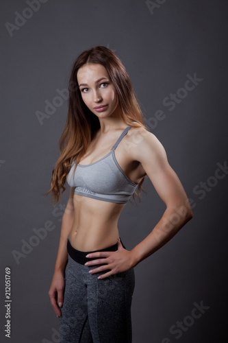 fitness trainer relaxed posing on grey background