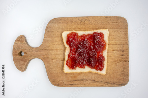 homemade slide bread with strawberry jam on the wooden broad isolated on white
