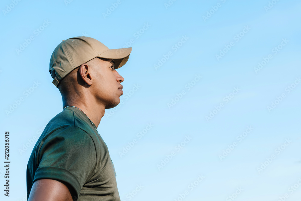 side view of african american soldier in cap against blue sky
