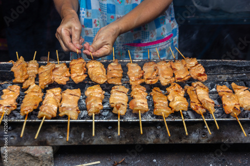 Obraz na plátně moo ping, grilled pork  skewer sticks on the bbq grill outdoor, Thai street food
