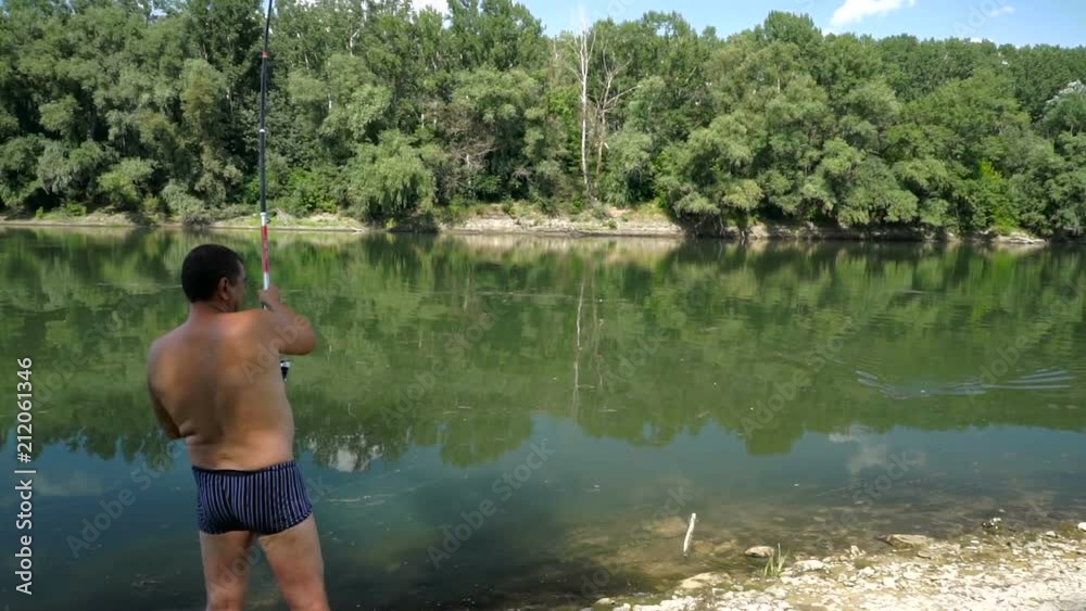 Fishing in river.A fisherman with a fishing rod on the river bank. Fishing in river.A fisherman with a fishing rod on the river bank.