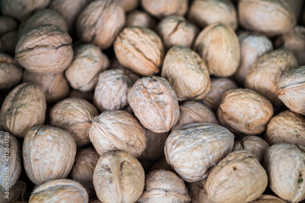 Backround of unpeeled english walnuts sold at local city market Backround of unpeeled english walnuts sold at local city market