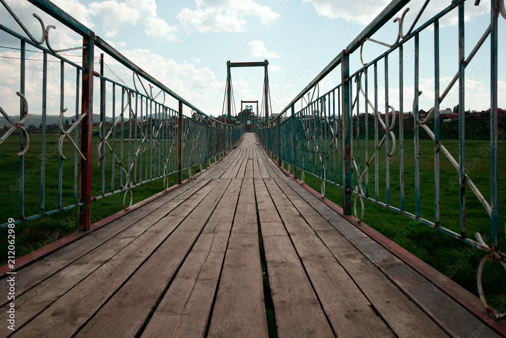 wooden  footbridge against blue summer sky in a park