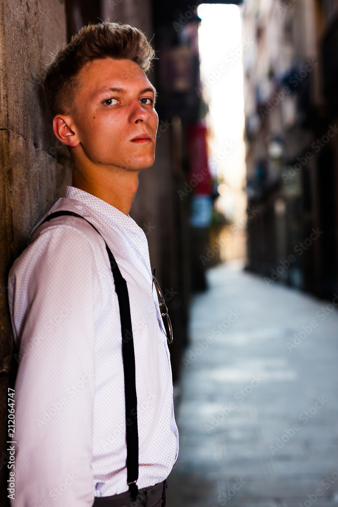 young European guy in shirt and trousers with suspenders walking around city young European guy in shirt and trousers with suspenders walking around city