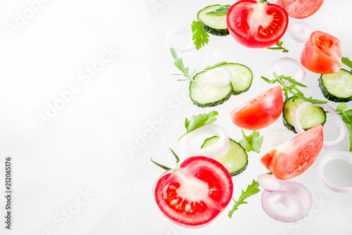Creative background, layout, concept of fresh healthy diet of salad, fresh raw  vegetables tomatoes parsley onions cucumbers greens, simple pattern on white background © ricka_kinamoto