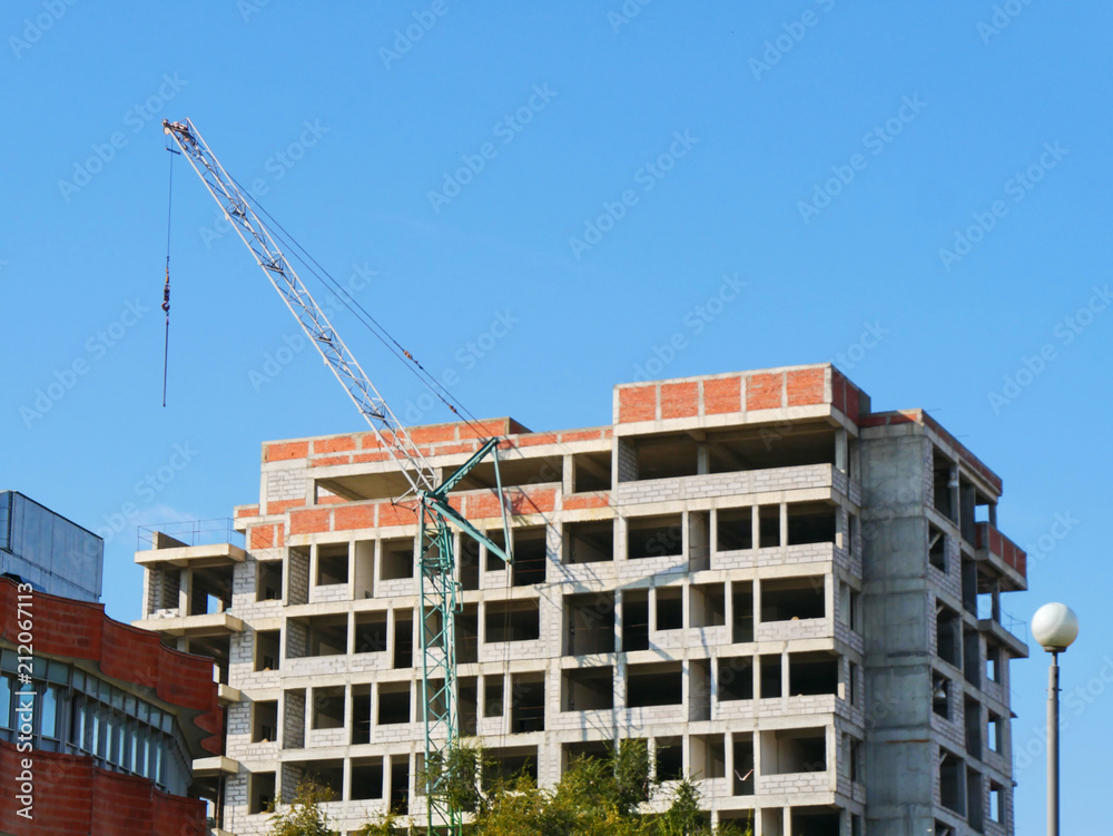 Building under construction against blue sky. Construction site.