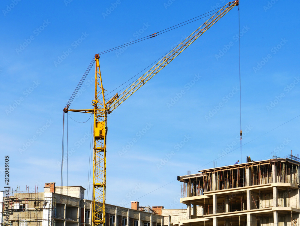 Construction site. Crane near building against blue sky.