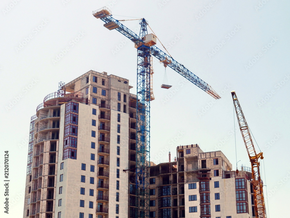 Two construction cranes near building. Construction site. Construction building.