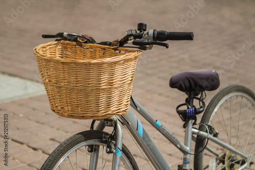 Bicycle with wicker basket on background