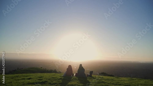 4K Young People having picnic on hill overlooking big city at sunset 5
