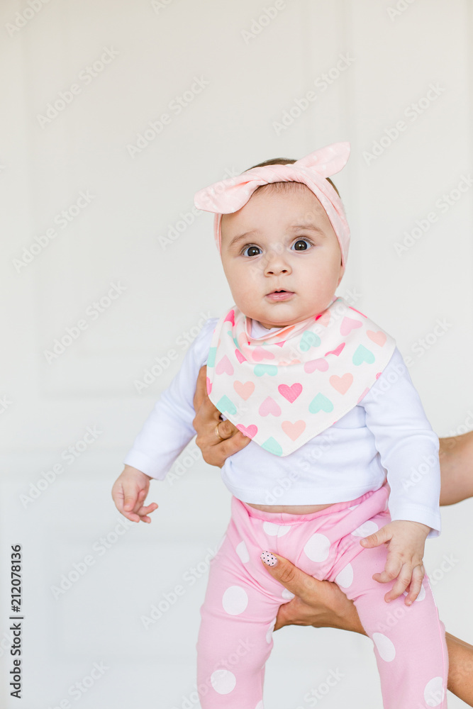 Cute baby on white background.Close up head shot of a caucasian baby girl, six months old baby looking at camera Cute baby on white background.Close up head shot of a caucasian baby girl, six months old baby looking at camera