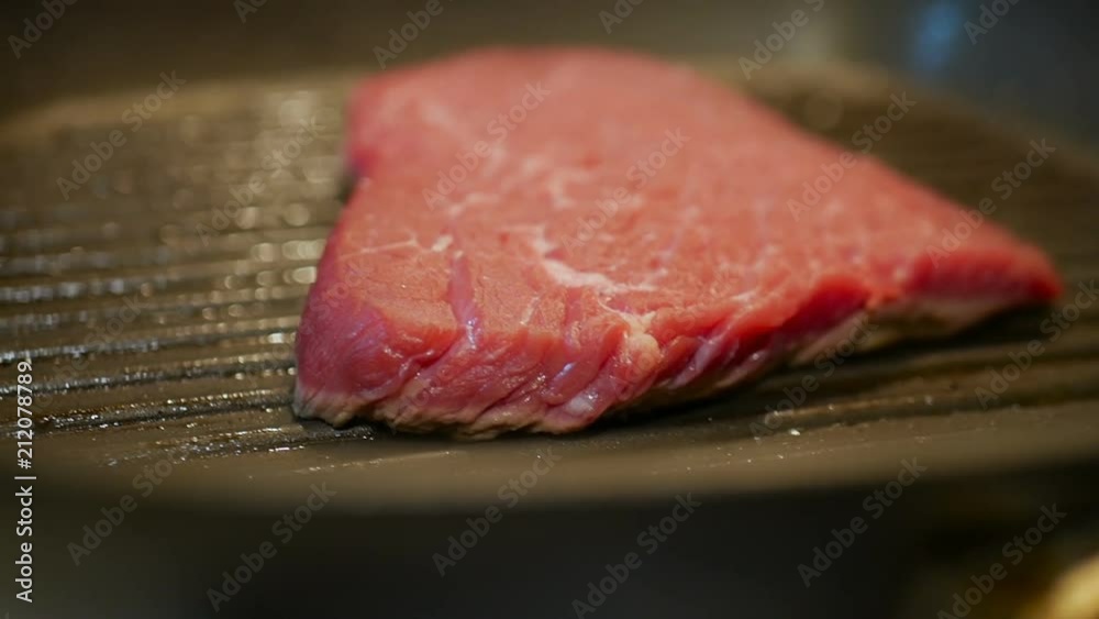 Cooking raw meat in slow motion. Pieces of meat are turned in a frying