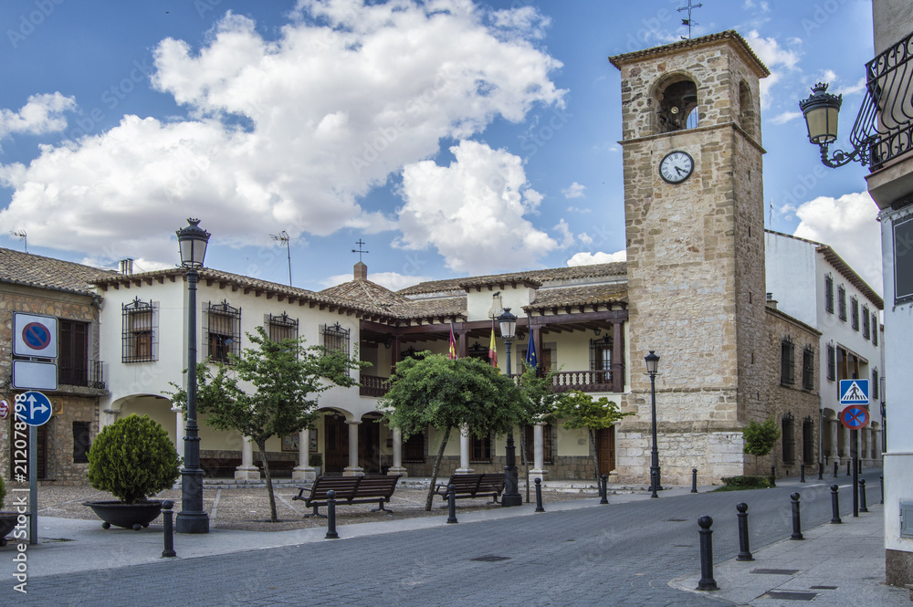 Plaza Mayor de Mota del Cuervo/plaza con bancos de madera, setos, edificios y ayuntamiento en Mota del Cuervo, provincia de Cuenca. Castilla La Mancha. España