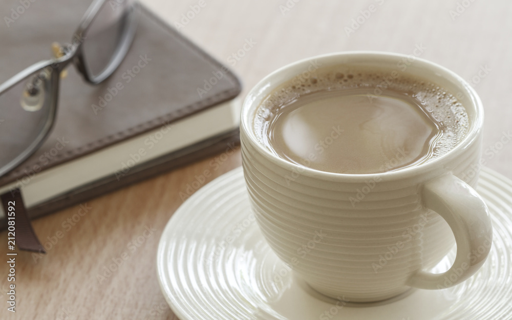 Cup Of Coffee And Eyeglasses With Book On Table In Morning. Cup Of Coffee And Eyeglasses With Book On Table In Morning.