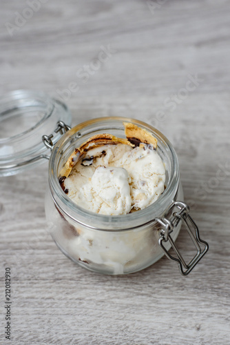 Homemade ice cream in a glass jar on a wooden background