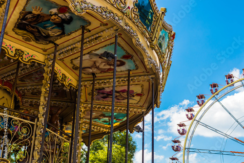 Amusement park. Carousel and Ferris wheel against the blue sky