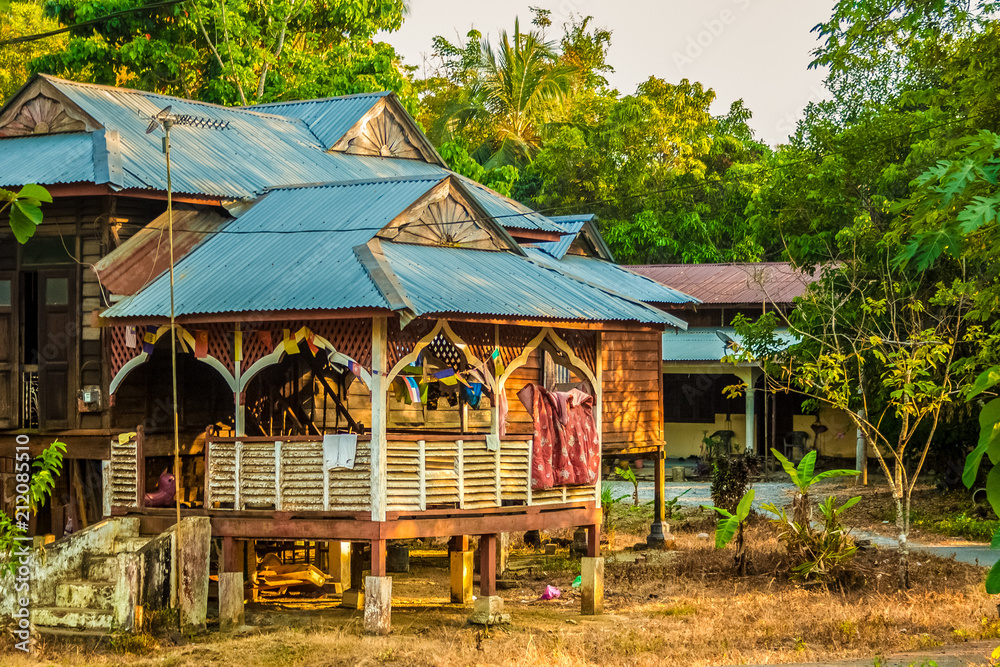 A traditional wooden Malay house on stilts with a tropicallysuited