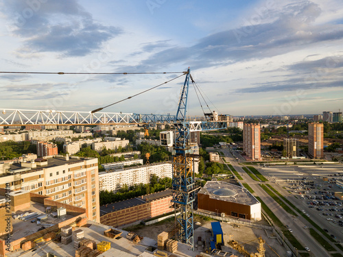 Aerial view of a new modern house under construction with a blue tower crane