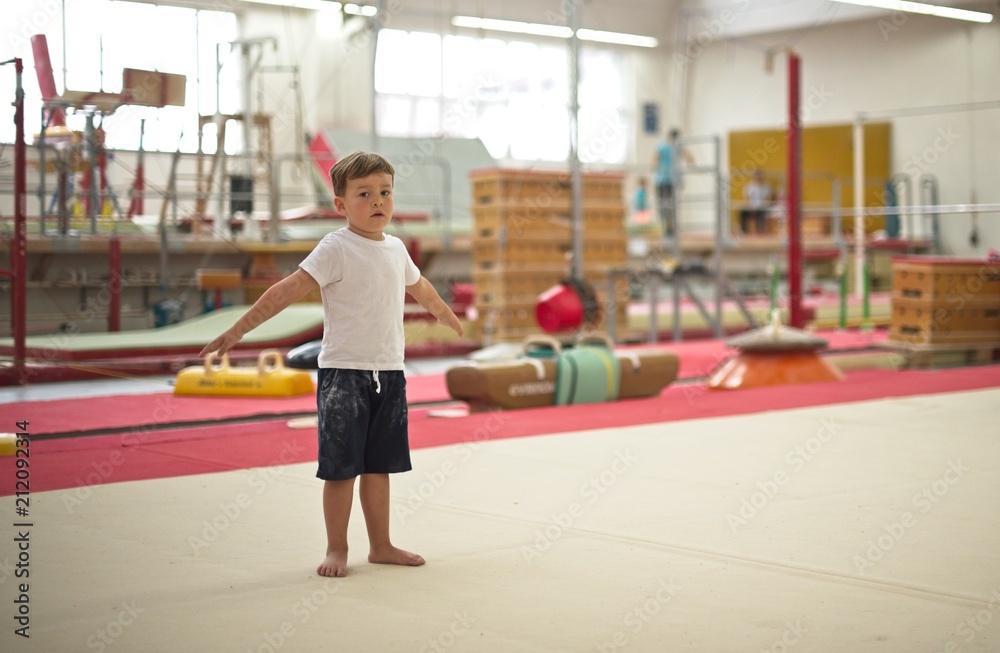 Little boy gymnast stands on the floor Little boy gymnast stands on the floor