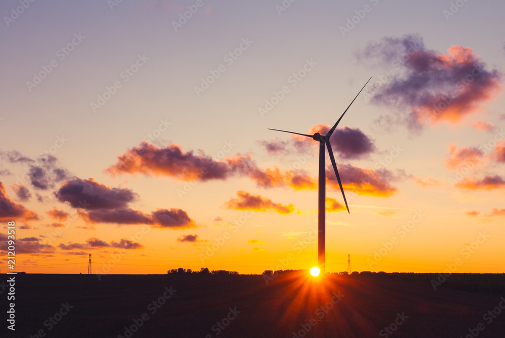 Obraz premium Wind turbines for electrical power generation in Normandy, France. Countryside and industrial landscape at sunset. Renewable energy sources. Environment friendly energy production