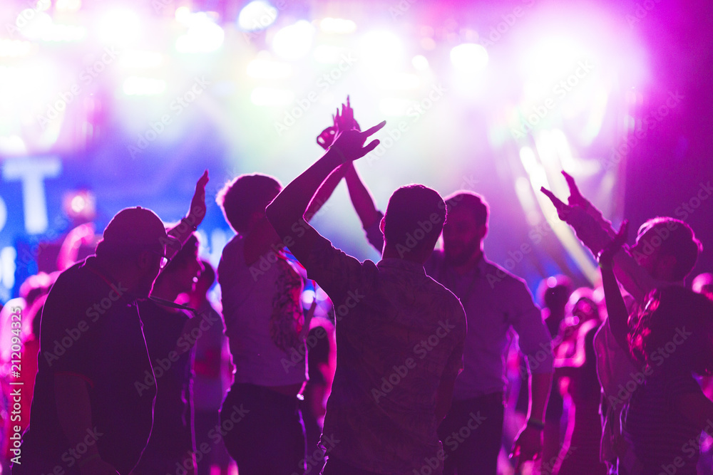 Bright colorful background with the silhouettes dancing young people during the performance favorite musician.