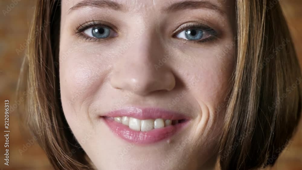 Young attractive girl is winking, smiling, fool around, watching at camera, brick background Young attractive girl is winking, smiling, fool around, watching at camera, brick background