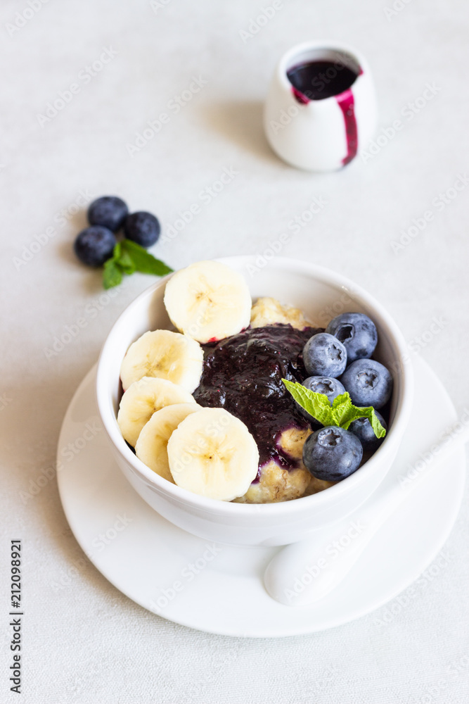 Porridge in a bowl with blueberries, banana and mint. Healthy breakfast concept Porridge in a bowl with blueberries, banana and mint. Healthy breakfast concept