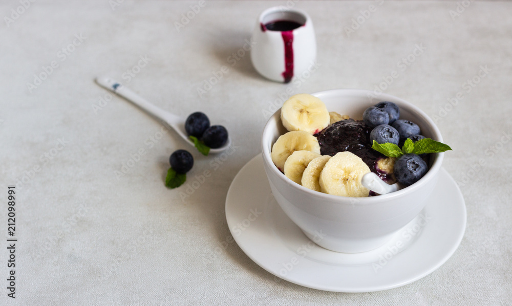 Porridge in a bowl with blueberries, banana and mint. Healthy breakfast concept Porridge in a bowl with blueberries, banana and mint. Healthy breakfast concept