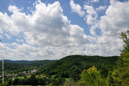 Scenic skyscape with full of windy clouds and beautiful green mountains in the countryside