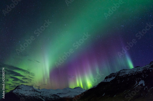 Northern lights above snowy mountains on Iceland