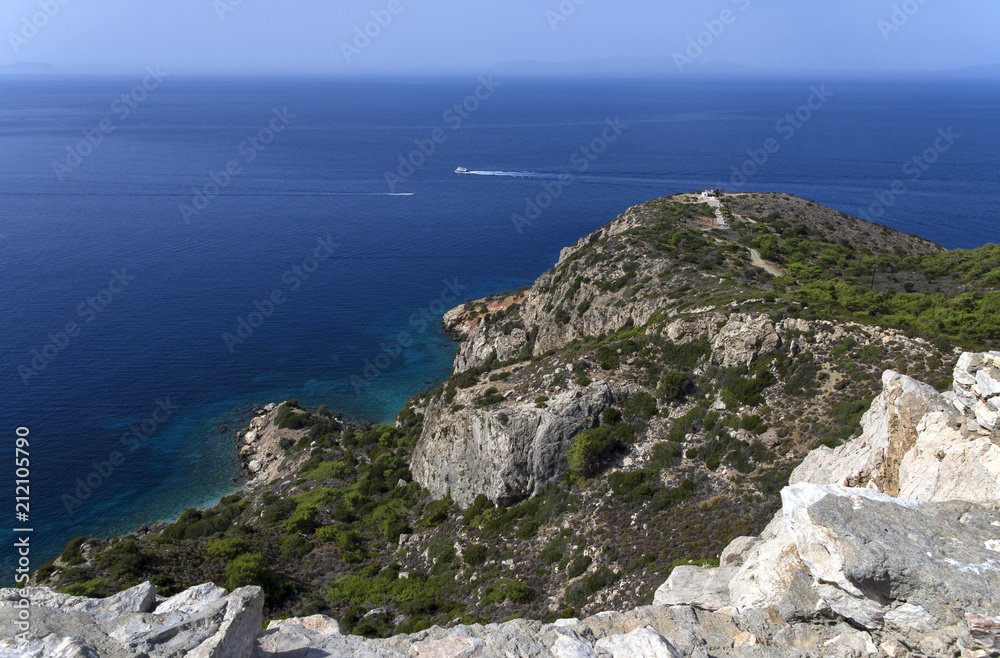 Seascape with two ships on the blue sea and a small Greek house at a strong distance on the island of Rhodes